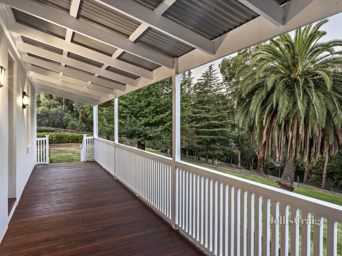 Repainted verandah with white balustrade, posts and ceiling over a stained timber deck