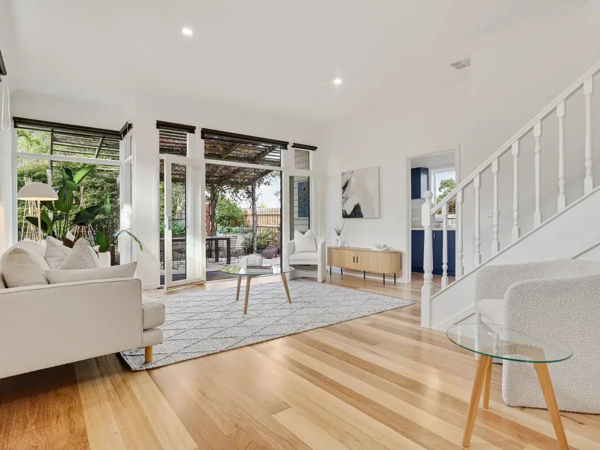 Renovated living room with timber floors, neutral furnishings and garden outlook — home renovation work in Bendigo