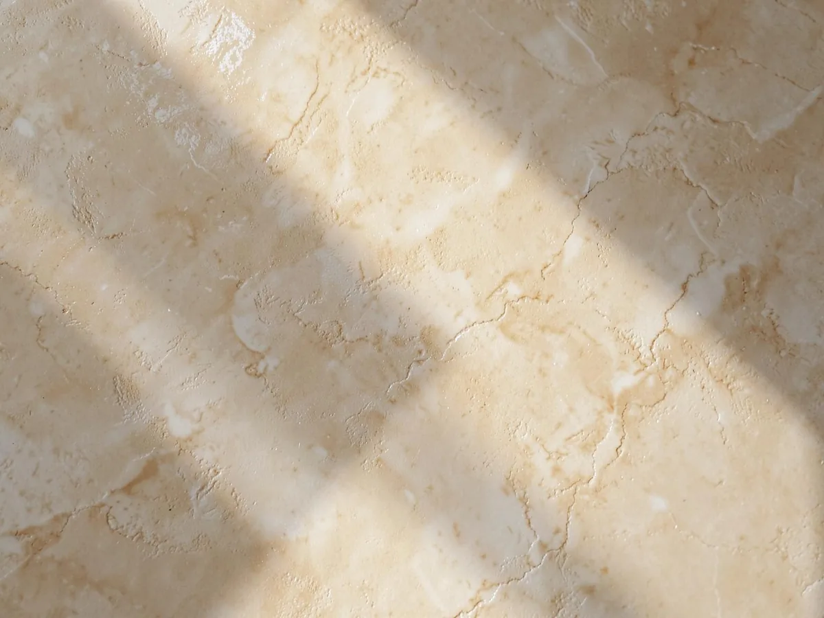 Polished beige Venetian plaster wall with soft marbled movement in raking daylight